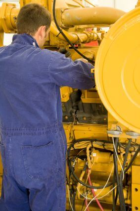 Engine maintenance A technician performing periodic engine maintenance in a landfill gas recovery plant
